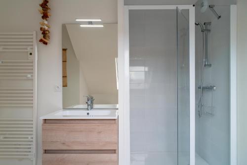 une salle de bain avec un lavabo et une douche dans l'établissement Ty Kenlou du Cabellou - Appartement sur la plage, à Concarneau