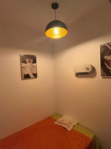 Habitación con cama, luz y fotografías en Apart Lamas Luxo en Paços de Brandão