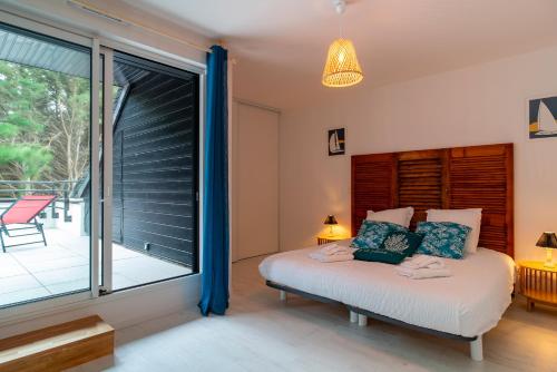 une chambre avec un lit et une grande fenêtre dans l'établissement Ty Kenlou du Cabellou - Appartement sur la plage, à Concarneau