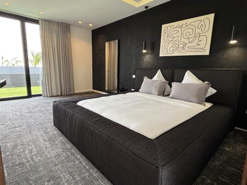 um quarto com uma cama grande e uma parede preta em Palais Kahli em Marrakech