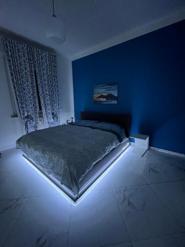 una camera con un grande letto in una camera blu di Luxury home stanza in appartamento condiviso a Cremona