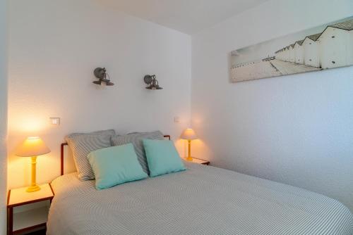 ein Schlafzimmer mit einem Bett mit zwei Lampen auf zwei Tischen in der Unterkunft Didou - T3 vue mer - plage à 40m in Bénodet