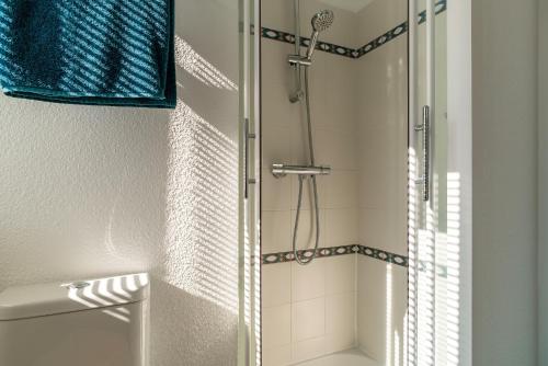 eine Dusche mit Glastür im Badezimmer in der Unterkunft Didou - T3 vue mer - plage à 40m in Bénodet