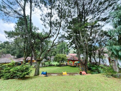 - une aire de jeux dans une cour arborée et une maison dans l'établissement Alamsagita Puncak Hotel & Resort, à Ciloto
