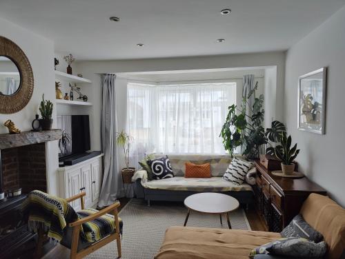 ein Wohnzimmer mit einem Sofa und einem Fenster in der Unterkunft Modern large en suite loft room in Bromley, London in Bickley