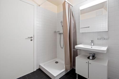 een witte badkamer met een wastafel en een toilet bij Boissonnet 96 Residence by Homenhancement in Lausanne