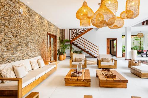 a living room with wooden furniture and a brick wall at Aldeia Jericoacoara - Suites Privativas in Jericoacoara