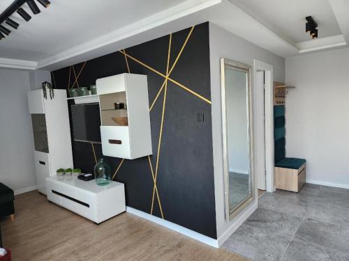 a living room with a black and gold wall at Apartament Zeromskiego in Ostróda