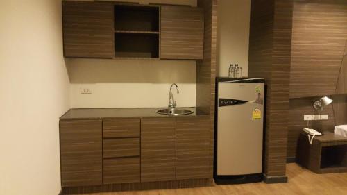 a kitchen with a refrigerator and a sink at H2 Hotel in Bangkok