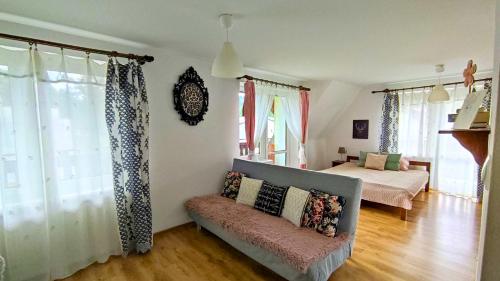 a living room with a bed and a couch at Muszynka Guest House in Muszyna