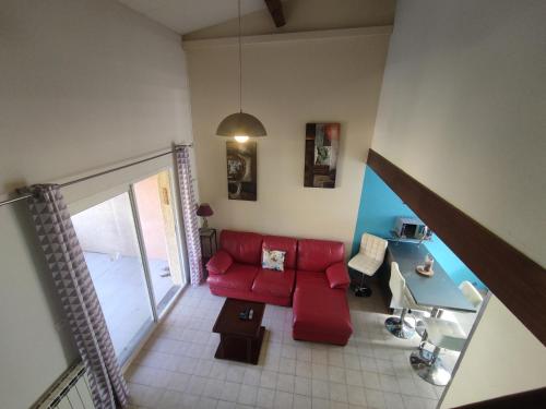 - un salon avec un canapé rouge dans l'établissement Villa 21, Cap Sauvage au village naturiste, au Cap d'Agde