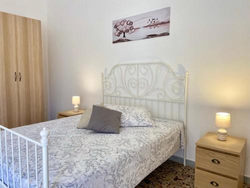 ein Schlafzimmer mit einem weißen Bett und zwei Nachttischen in der Unterkunft La casa di Nina in Surano