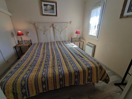 - une chambre avec un lit doté d'un couvre-lit coloré dans l'établissement Villa 21, Cap Sauvage au village naturiste, au Cap d'Agde