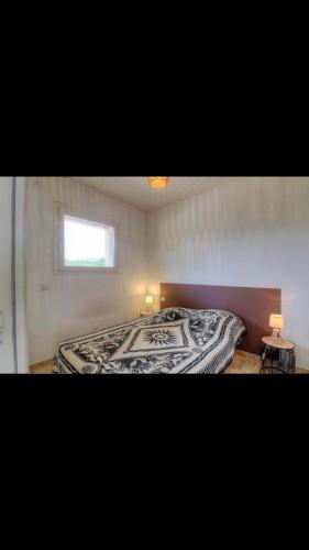 une chambre avec un lit avec une couette noire et blanche dans l'établissement Appartement proche des plages, à Porto-Vecchio