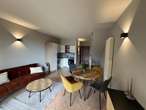 ein Wohnzimmer mit einem Sofa, einem Tisch und Stühlen in der Unterkunft Casa Di Tino by GadraDoma in Assenza di Brenzone