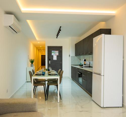 eine Küche und ein Esszimmer mit einem Tisch und einem Kühlschrank in der Unterkunft RA6 - NEW, bright & spacious - Sliema-Gzira area! in Gżira