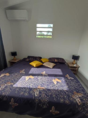 - un lit avec une couette et des oreillers bleus dans l'établissement Les cattleyas, à Petit-Bourg
