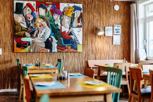 a restaurant with tables and chairs and a painting on the wall at Das Esel - Kleinod in Rust in Rust