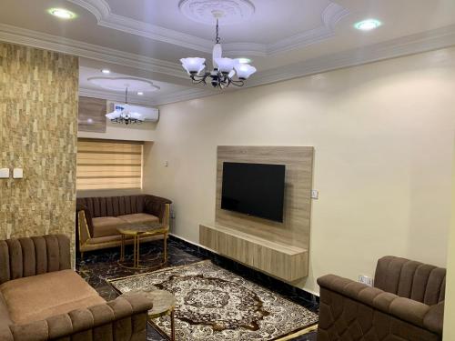 a living room with a flat screen tv on a wall at an exquiste 3 bedroom apartment, in a peaceful environment in Abuja