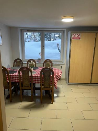 a dining room with a table and chairs and a window at Villa Vincentów in Myślenice