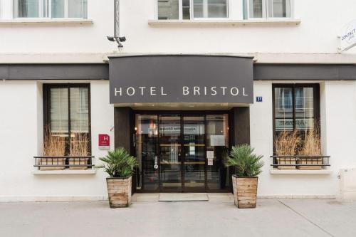 a hotel british storefront with potted plants in front of it at L'Hôtel Bristol in Caen
