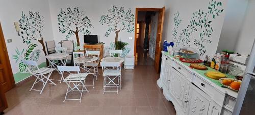 a kitchen with a table and chairs and trees on the wall at I Sollazzi in Palermo