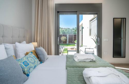 een slaapkamer met een groot bed en een groot raam bij Villa MANDI & JANI by "elite" in Laganas