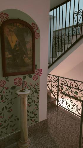 a stairway with a painting on the wall and a stair railing at I Sollazzi in Palermo