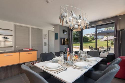 una sala da pranzo con tavolo e sedie bianchi di Casa Tramontana by Briskva a Funtana