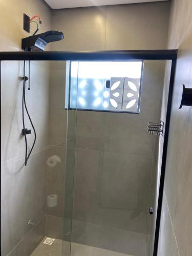 W łazience znajduje się prysznic ze szklanymi drzwiami. w obiekcie Loft de luxo w mieście Araxá