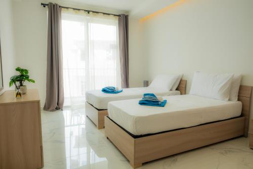 1 Schlafzimmer mit 2 Betten, einem Sofa und einem Fenster in der Unterkunft RA6 - NEW, bright & spacious - Sliema-Gzira area! in Gżira