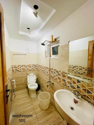 La salle de bains est pourvue de toilettes et d'un lavabo. dans l'établissement Hotel five star Skardu, à Skardu