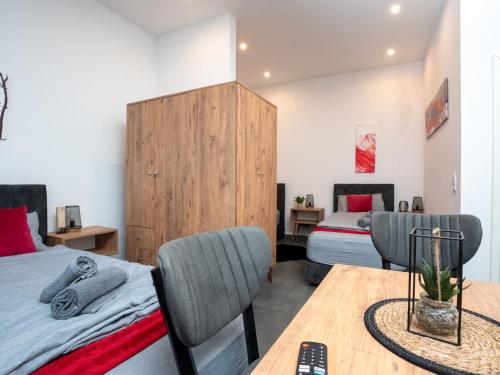 a bedroom with two beds and a table and chairs at Serviceroom24 - Apartment 2 in Recklinghausen Hoch WLAN - Smart-TV - 24-7 Check-in und Küche in Recklinghausen