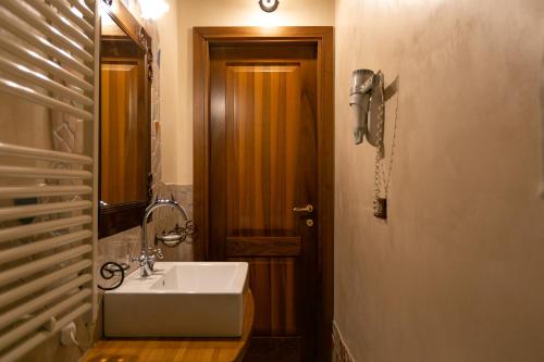 a bathroom with a sink and a wooden door at Il Podere Del Germano Reale in Coriano