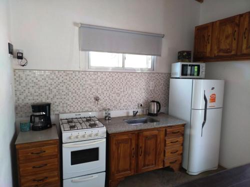 uma cozinha com um frigorífico branco e um fogão branco em Quinta Los Altares em Bragado