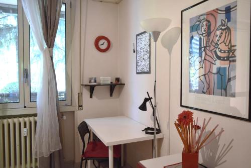 Habitación con escritorio blanco y ventana. en Casa Laghetto San Donato Policlinico, en San Donato Milanese