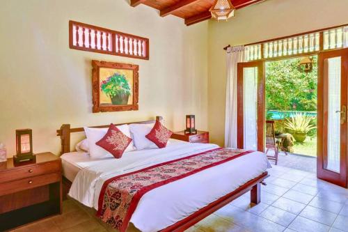 a bedroom with a large bed and a large window at Jineng 5 BR Private Pool Villa with Stunning Garden by Basma Groups in Ubud
