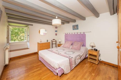 - une chambre avec un lit rose et du parquet dans l'établissement L'Errekaldea - Vue montagne et piscine privée, à Masparraute