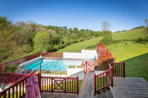 une piscine sur une passerelle en bois à côté d'une colline dans l'établissement L'Errekaldea - Vue montagne et piscine privée, à Masparraute