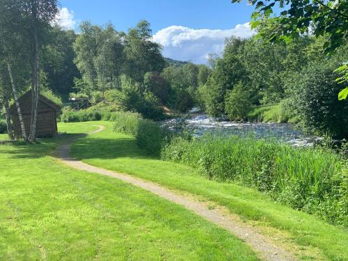 a path through a field next to a river at Guddals Tunet in Rosendal