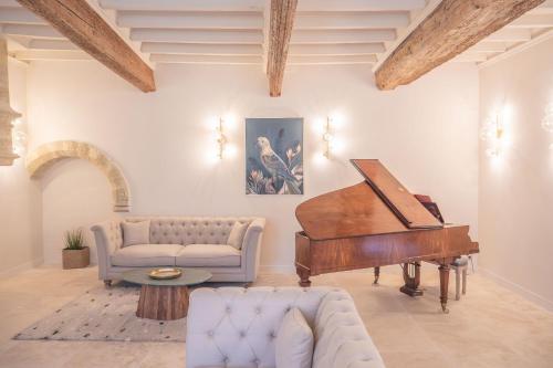 - un salon avec un piano et un canapé dans l'établissement Château du Parc - Gîtes & spas à Pézenas, à Pézenas