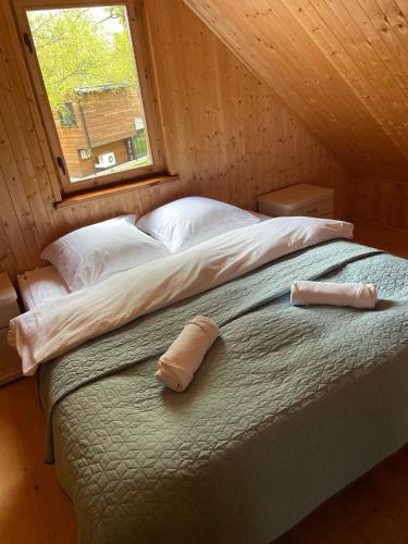 a bedroom with a bed with two pillows on it at Domki Letniskowe Nad Jeziorem Kazub in Cieciorka