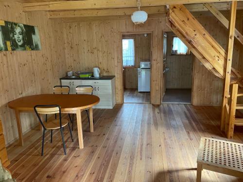 a kitchen with a table and chairs in a room at Domki Letniskowe Nad Jeziorem Kazub in Cieciorka