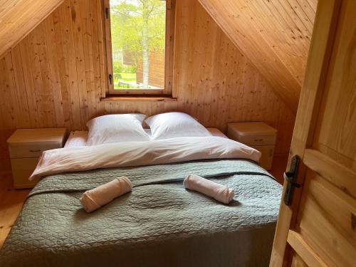 een bed in een houten kamer met twee kussens erop bij Domki Letniskowe Nad Jeziorem Kazub in Cieciorka