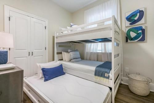 - une chambre blanche avec des lits superposés et un oreiller bleu dans l'établissement Urban Retreat Near French Quarter, à La Nouvelle-Orléans