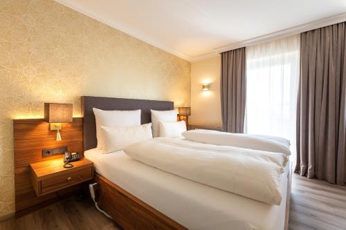 a hotel room with a large bed and a window at Holzapfel in Bad Füssing