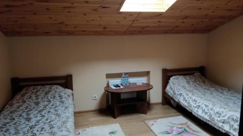 a room with two beds and a table in it at Готель-ресторан Chalet in Bila Tserkva