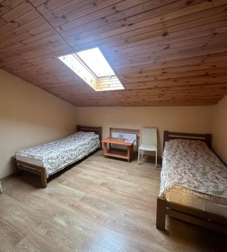 a bedroom with two beds and a table and a skylight at Готель-ресторан Chalet in Bila Tserkva