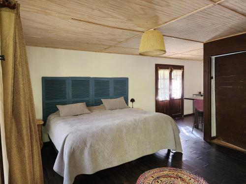 une chambre avec un grand lit et une tête de lit bleue dans l'établissement Cabaña Jacuzzi Interior, à San José de Maipo