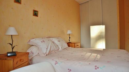 um quarto com uma cama, 2 candeeiros e uma janela em T2 au 1er étage - SAINT CAST LE GUILDO em La Garde